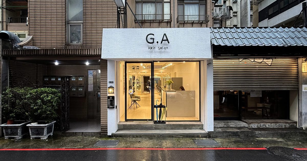 G.A Hair Salon 忠孝東路 216 巷店面外觀,雨後夜色中的白色招牌與明亮落地窗